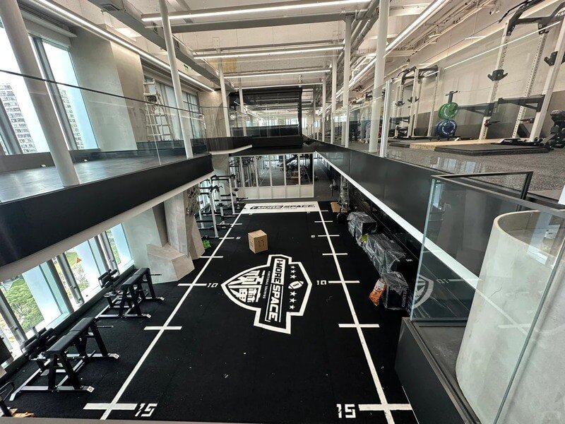 Engineer comparing samples of padded gym turf, highlighting differences in pile height and foam thickness for selection.